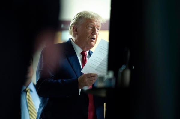 Former President Donald Trump holds papers moments before stepping on stage to address an audience at a campaign event, Monday, Oct. 9, 2023, in Wolfeboro, N.H.
